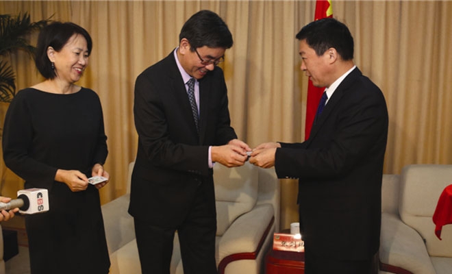 Zhang Jianwei (center) and Guo Ying (left) receive their 